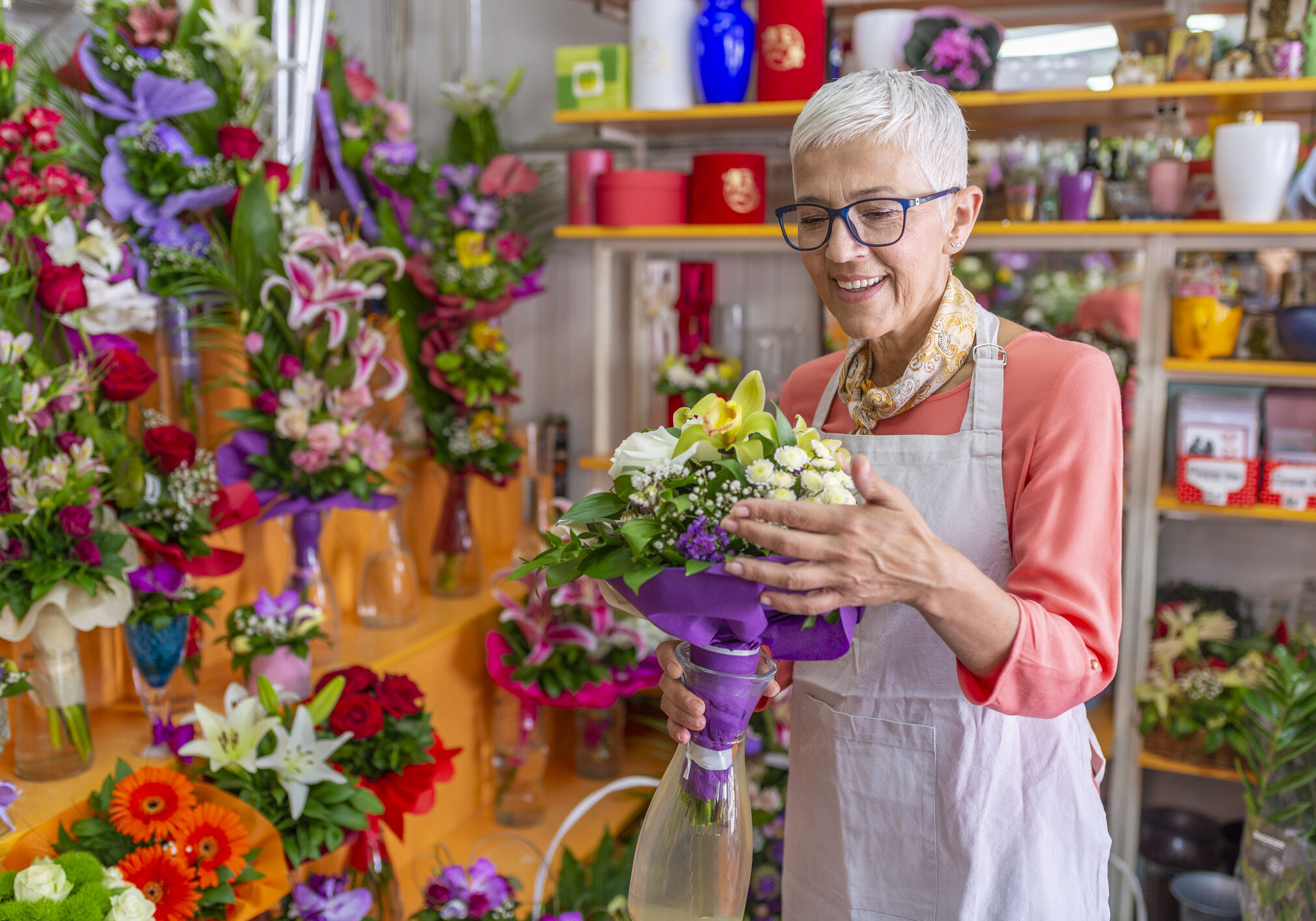 Woman working in flower shop. Smiling Mature Woman Florist Small Business Flower Shop Owner. Florist woman working in a flower shop. Small business. Flowers delivery, creating order